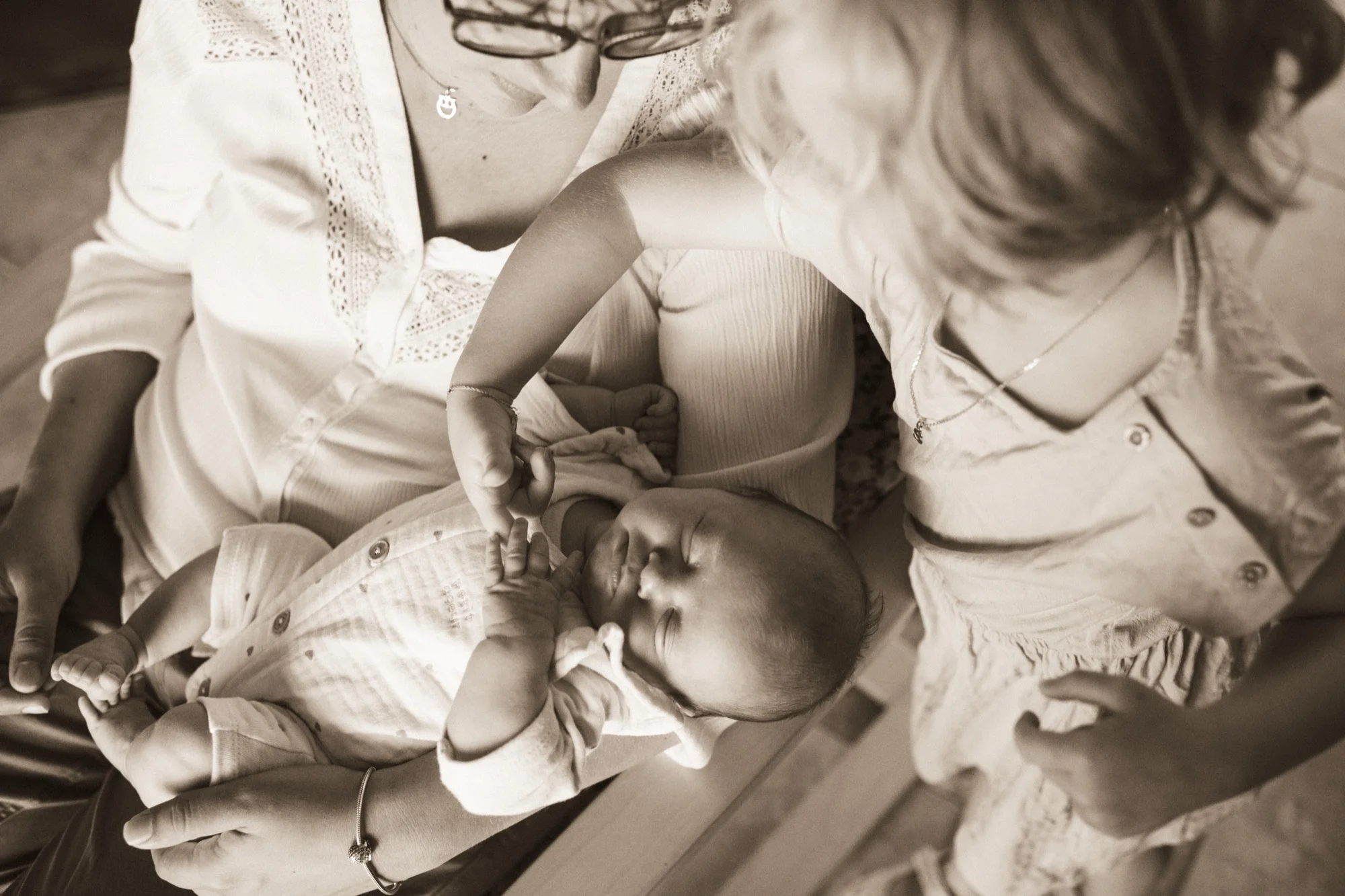 Bébé endormi dans les bras de sa famille, dans une scène de vie douce et intime